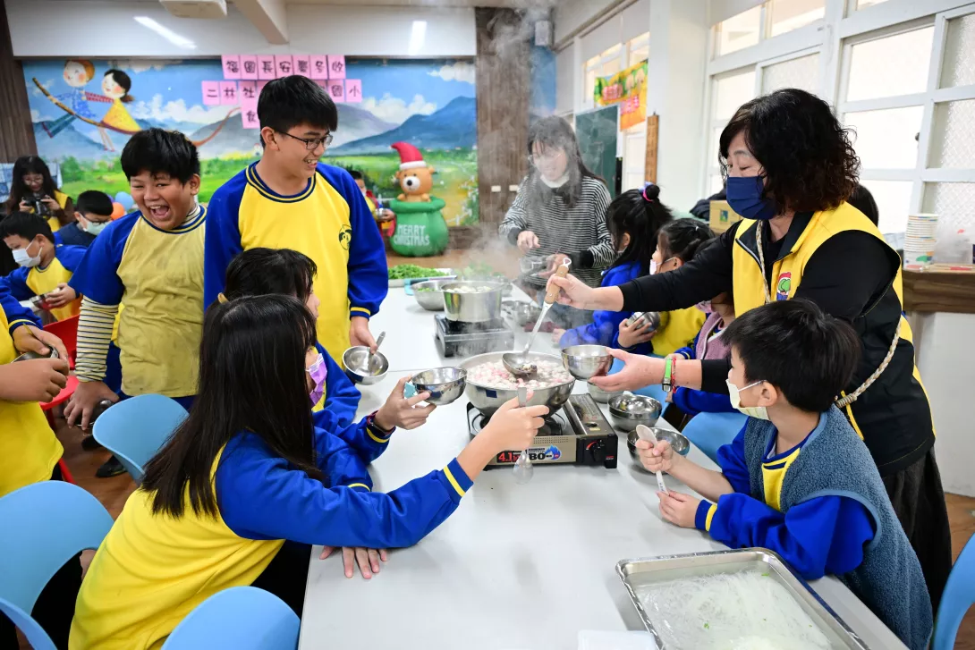 圖:二林社大志工協助低年級學生盛湯圓。