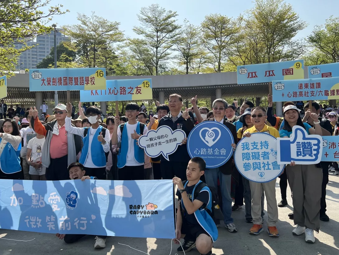 健走出發前舉牌合照(前排中高雄市勞工局江建興局長、右三心路李樑堅董事、右二公聖保經蔡文俊董事長、右一心路支持服務處周耕妃處長)_ s