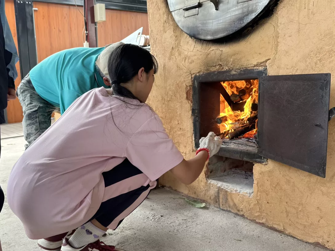 圖:劈柴生火準備烤窯,培養耐心與團隊精神。(芥菜種會提供)
