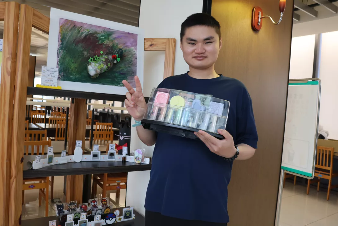 在伊甸老師的引導下,自閉症的阿辰運用多元媒材,完成了大幅的藝術創作《草原上的明亮燈塔》。