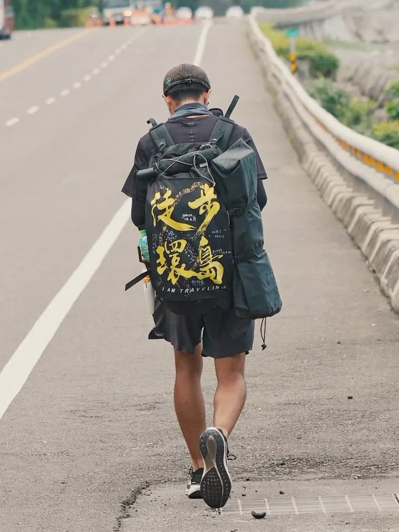 圖三:一人、一背包、一條公路。邱柏辰背著寫著「徒步環島」的背包,一步步走出夢想的輪廓。