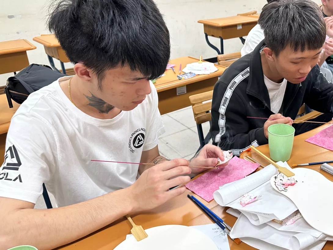 圖二:學生專心進行拼貼構圖與技法實作,透過層層貼紙與花草素材,感受地方記憶與情感的傳遞,展現文化美學的落地實踐。