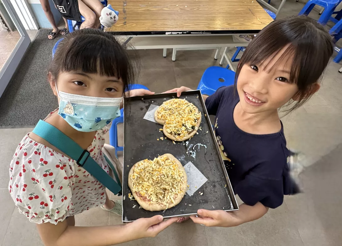 孩子開心的展示自己做的比薩