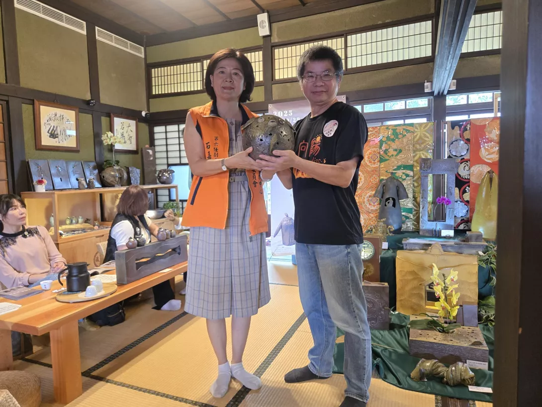 照片1-何應朋老師(右)捐贈個人精心創造的窯燒陶藝品,由石嘉玫副主委(左)代表受贈