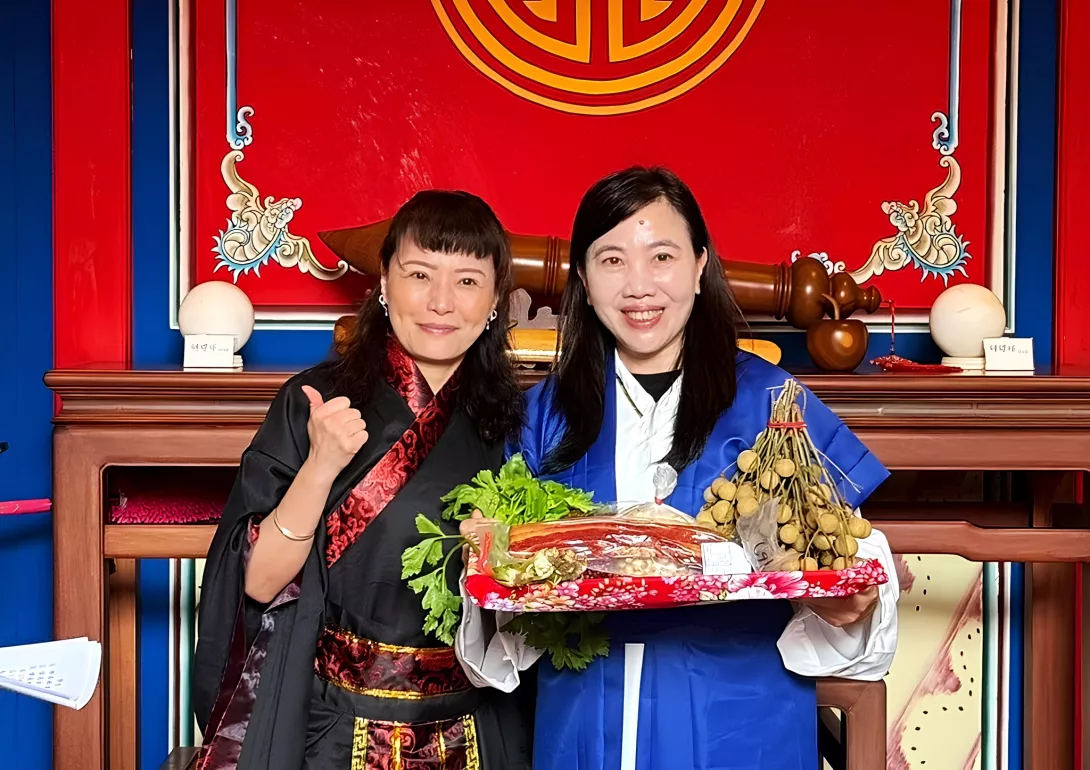 EMBA新生奉上象徵勤勉學習不忘師恩的「束脩六禮」,與系主任陳美夙(右)合影。