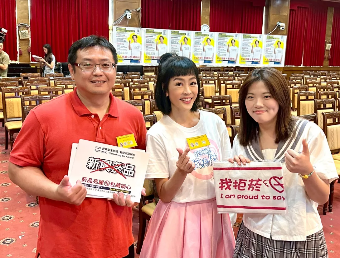 義工唐玲與學務主任楊仁杰、小粉絲時尚造型科陳同學合影