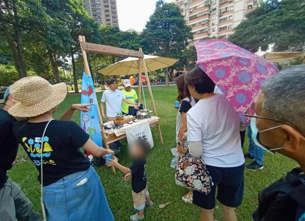 (圖一)孩子們在社區義賣攤位上與民眾互動,展現勇敢與溫暖