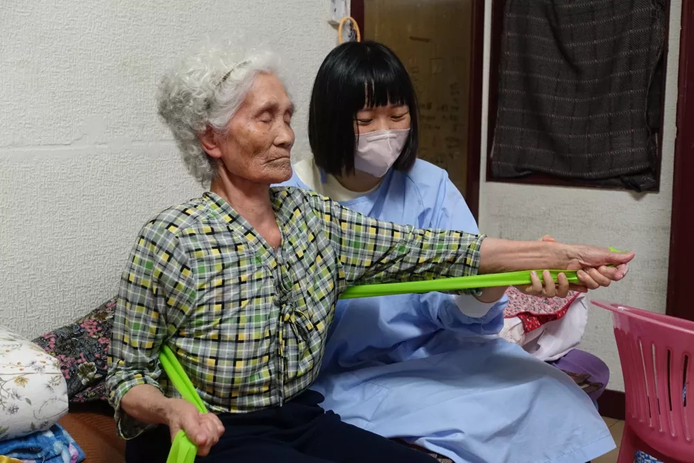 物理治療師陳怡同入家協助長輩復健。攝/葉靜倫