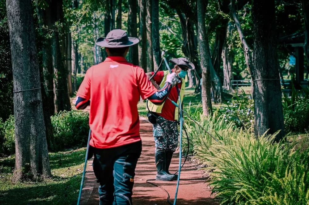 友洗社創的勞工在烈日下的大安森林公園進行病媒蚊防治工作。圖/林立青 fb