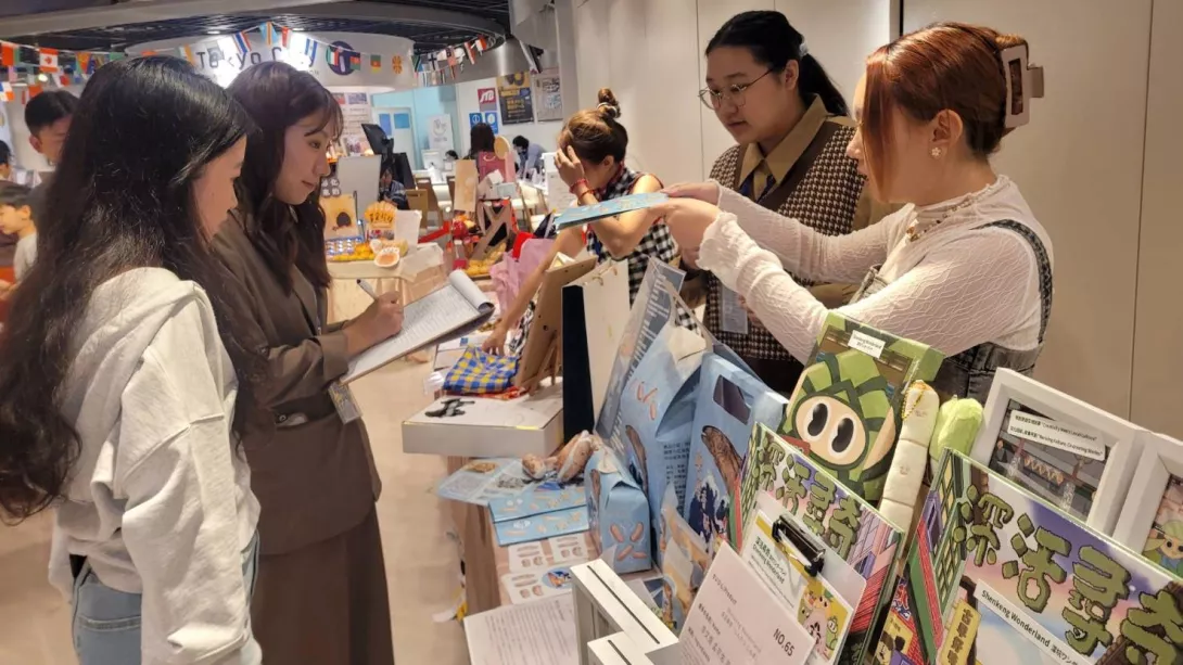 圖三:東南科大參賽學生向日本觀展者介紹《海魚香酥》與《深活尋奇》等設計作品,吸_0