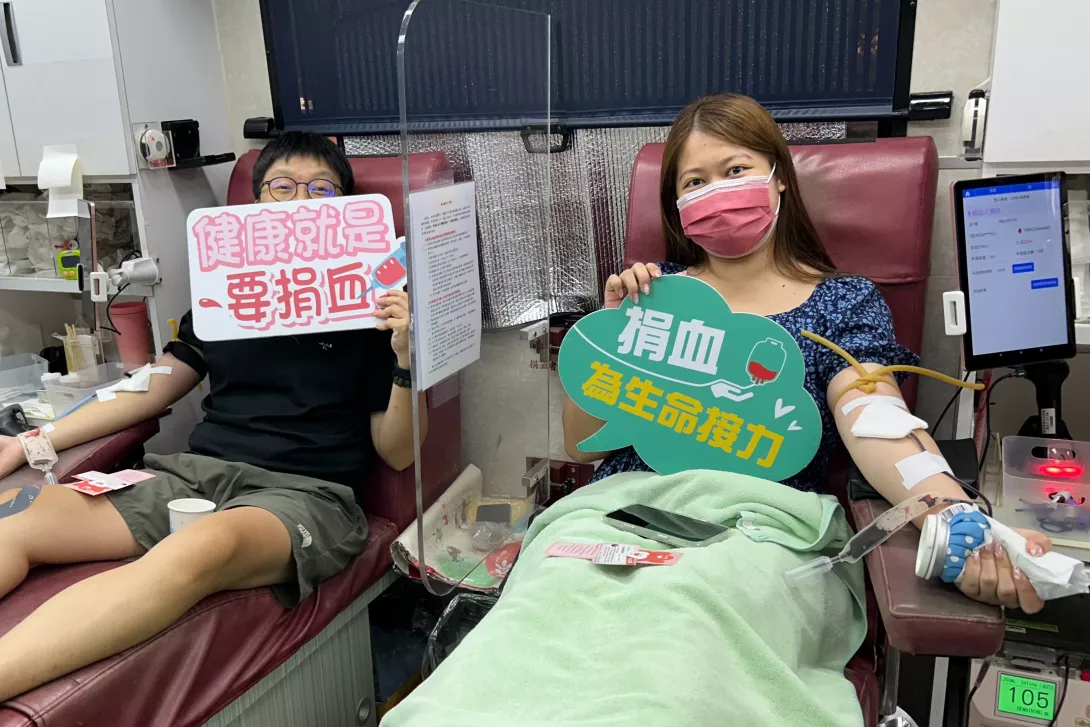 圖二:教職員生熱情響應「第一滴血」,手持「健康就是要捐血」、「捐血為生命挹注力量」,展現的愛心與責任感。