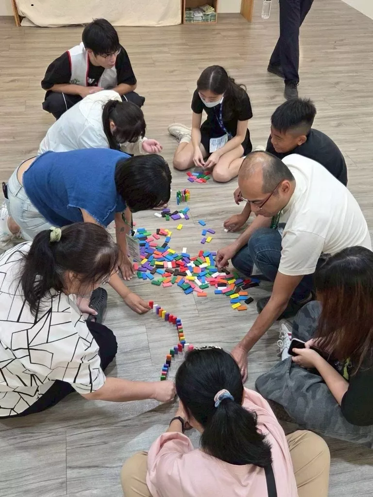 在骨牌活動中,大家共同合作,每個人動作都非常輕巧,仔細地排列著圖形